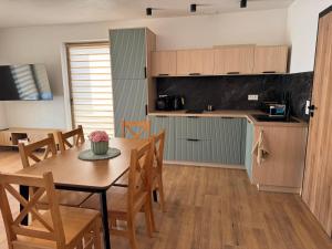 a kitchen and dining room with a table and chairs at Apartamenty Polna Ostoja in Tylicz