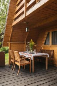a wooden table and chairs on a deck at Mała Toskania in Kawec +16 photos
