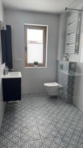 a bathroom with a tub and a toilet and a sink at Apartamenty Polna Ostoja in Tylicz