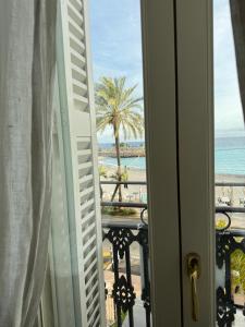 a view of the beach from a room with a window at Maison Menton in Menton