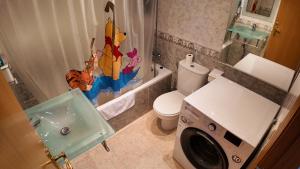 a bathroom with a toilet and a washing machine at Apartalux Magic Paradise in Oropesa del Mar