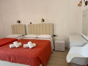 a bedroom with two beds with towels on the bed at Regina Nina in Vasilátika
