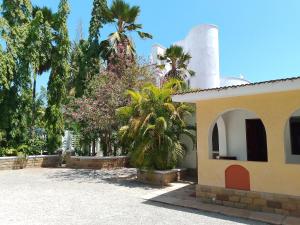 a building with trees and palm trees in a yard at Kamsons in Mombasa