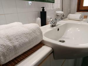 a white bathroom with a sink and a towel at Casa dell' Onda 25 in Siena +35 photos