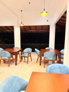 a dining room with tables and chairs and lights at Rainforest Mount Lodge in Deniyaya