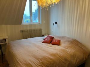 a bedroom with a bed with two red pillows on it at Reve dOpale in Étaples