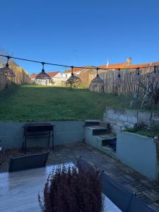 a backyard with a lawn with a table and a fence at Reve dOpale in Étaples