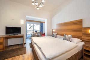 a bedroom with a large bed and a flat screen tv at MIA Appartements - non-serviced Appartements in Obertauern