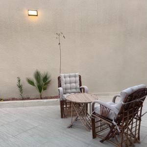 two chairs and a table in a room at شقة مشراق in Al-ʿUla