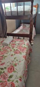 two bunk beds in a room with a floral bedspread at Residencial Mineiro- apartamento de 02 quartos in Itapoa