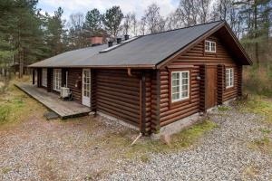 a log cabin with a porch and a roof at HA398-Saeby-Kulmulevej-9 in Lyngså