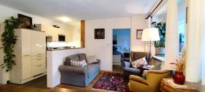 a living room with two chairs and a kitchen at Apartment Ischl Home in Bad Ischl
