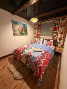a bedroom with a bed with a quilt on it at Leśna 6 in Sierakowo