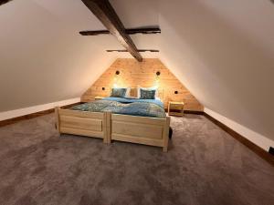 a bedroom with a wooden bed in a attic at Leśna 6 in Sierakowo