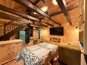 a living room with a table and a television in a cabin at Leśna 6 in Sierakowo