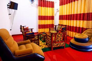 a living room filled with furniture and colorful curtains at Wilpattu Gagana guest in Nochchiyagama
