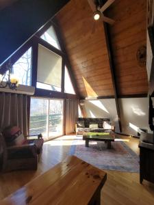a living room with a wooden ceiling and a table at Roaring Fork Chalet in Burnsville