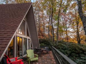 a porch of a house with chairs and tables at Roaring Fork Chalet in Burnsville