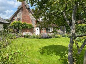 an old brick house with a grass yard at Thatch Cottage Singleton 2 miles from Goodwood in Singleton