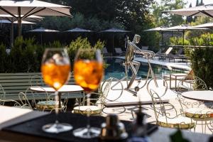 two wine glasses sitting on a table next to a pool at Villa Bocchi by Geco Vacation Rentals in Negrar +55 photos