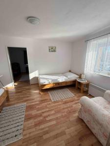 a living room with a bed and a wooden floor at Apartmans ZBYTINY 21 in Zbytiny