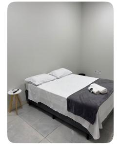 a bedroom with a bed with two towels on it at Quartos Sinop in Sinop