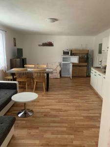 a living room with a table and chairs and a kitchen at Apartmans ZBYTINY 21 in Zbytiny