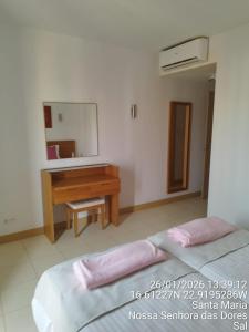 a bedroom with a bed and a desk and a mirror at Mb HOUSE VILA VERDE RESORT in Prainha