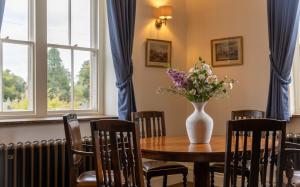 a dining room table with a vase of flowers on it at The Lower Buck Inn in Clitheroe +49 photos