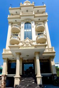 a large white building with stairs in front of it at Nhất Thống Hotel in Cao Lãnh