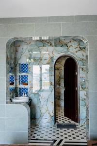 a bathroom with a stone wall with a door and a sink at Nhất Thống Hotel in Cao Lãnh