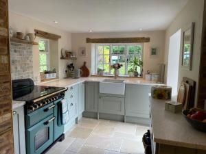 a kitchen with a sink and a stove top oven at Thatch Cottage Singleton 2 miles from Goodwood in Singleton +7 photos