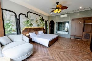 a bedroom with a bed and a couch at Nhất Thống Hotel in Cao Lãnh