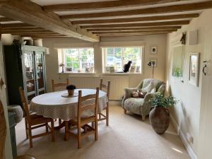 a dining room with a table and a chair at Thatch Cottage Singleton 2 miles from Goodwood in Singleton