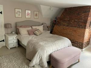 a bedroom with a bed and a brick wall at Thatch Cottage Singleton 2 miles from Goodwood in Singleton