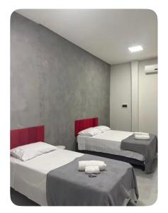 a room with two beds with towels on them at Quartos Sinop in Sinop