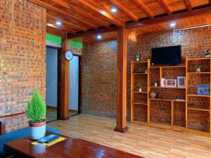 a living room with a brick wall and a tv at Family Private Villa Hội An in Hoi An