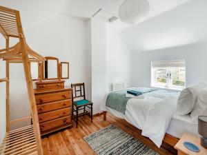 a bedroom with a bed and a wooden dresser at The Pink Cottage in Bottisham