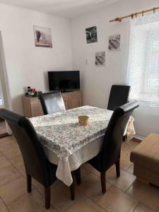 a dining room table with chairs and a tablecloth on it at Apartmans ZBYTINY 21 in Zbytiny