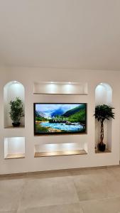 a flat screen tv on a wall in a room at Casa Bali centre ville in Brie-Comte-Robert