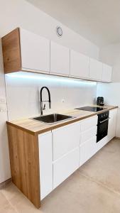 a kitchen with white cabinets and a sink at Casa Bali centre ville in Brie-Comte-Robert