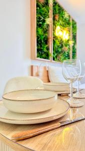 a table with plates and wine glasses on a table at Casa Bali centre ville in Brie-Comte-Robert