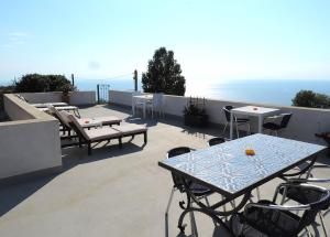 a patio with tables and chairs on a roof at Casa Alicudi in Lipari