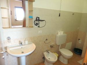 a bathroom with a sink and a toilet and a mirror at Casa Alicudi in Lipari