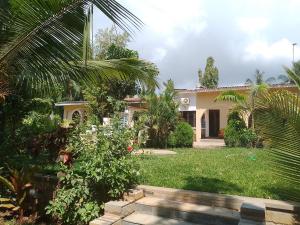 a house with a palm tree in the yard at Kamsons in Mombasa +7 photos