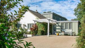 a white house with a white pergola at Blackshore House in Wenhaston