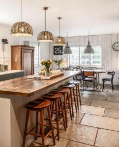 a kitchen with a long counter with stools in it at Blackshore House in Wenhaston