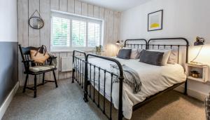 a bedroom with a bed and a chair and a window at Blackshore House in Wenhaston