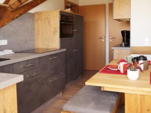 a kitchen with black cabinets and a wooden table at Winzerhof Weber in Buggingen