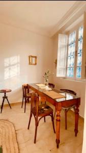 a dining room with a wooden table and chairs at Studio Authentique à Sidibousaid in Dar Salah Bey